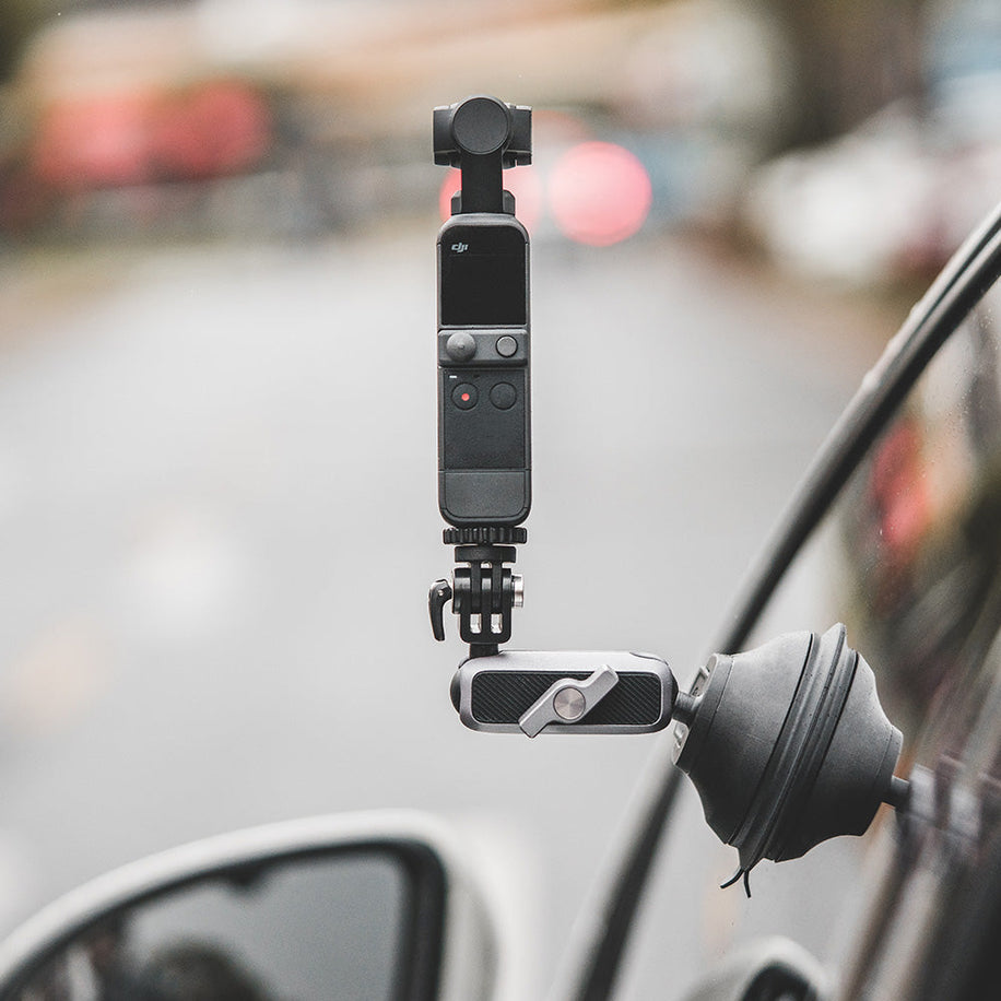 action camera suction cup — Mounted on car window, street background